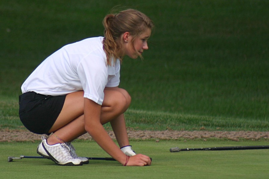 A member of the golf team last year lines up a putt during a golf practice last season. 