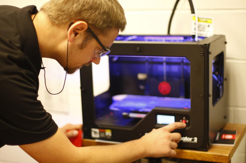 Engineering and technology instructor Paul Cross uses the departments 3D printer. The department first acquired the printer during the summer of 2013. Photo by Jakob Phillips
