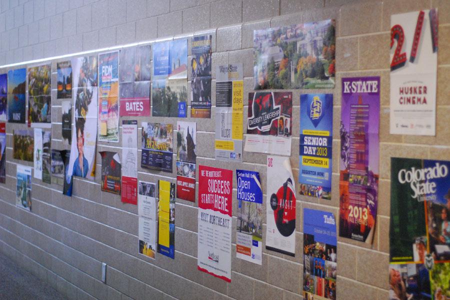 College posters cover the wall outside the Guidance IMC.  Only 8 percent of low-income students graduate from college by age 24; for students in the top income quartile, the figure is 73 percent.