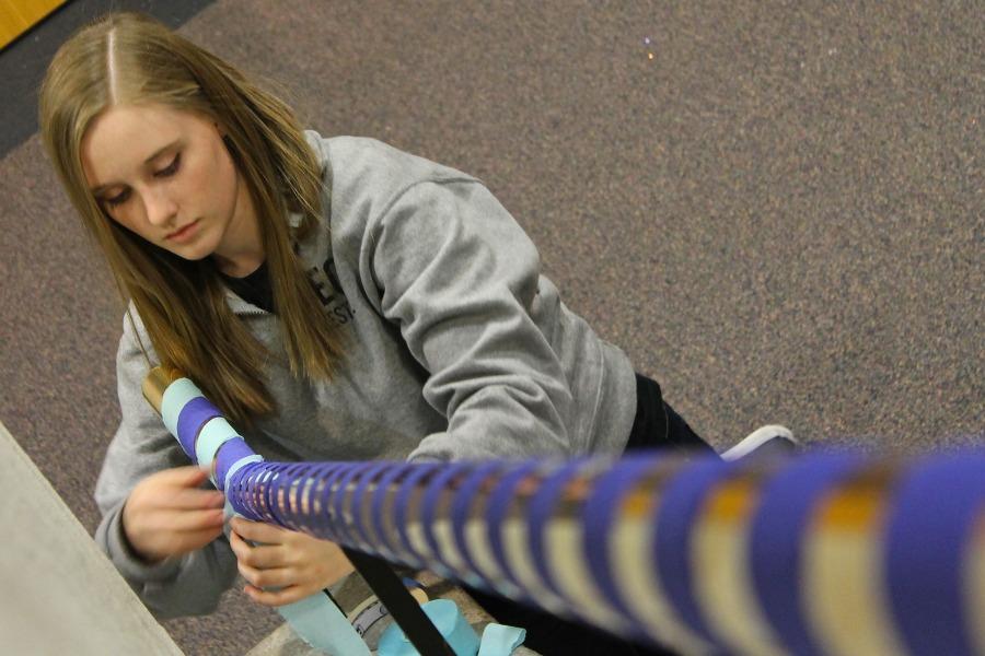 Former Senior Ellie Pribus prepares decorations for Winter formal. This years the theme is a night in paris. 