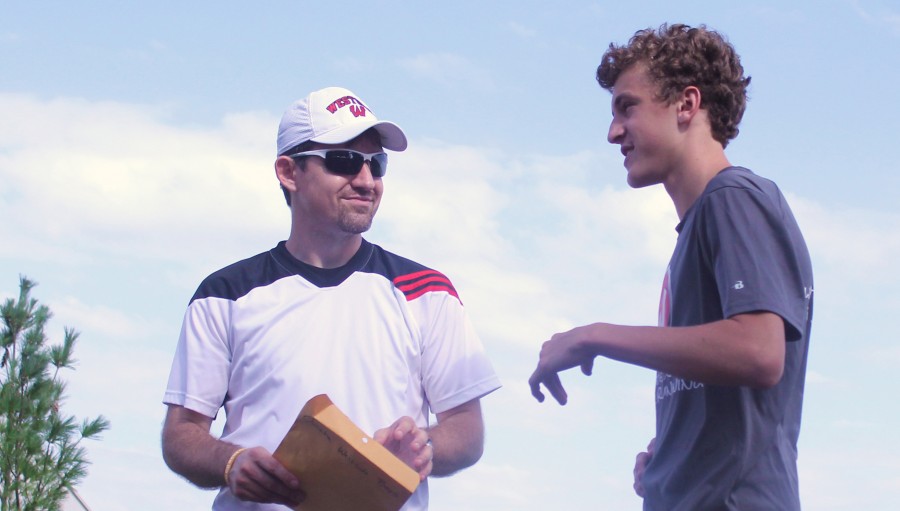 Boys cross country coach Andrew Easton talks strategy with sophomore Milo Greder before the Charlie Thorell Invitational held Thursday, Sept. 5 in Seward, NE. The varsity boys won the meet for the first time in school history with five runners medaling in the top 20. Photo by Jakob Phillips