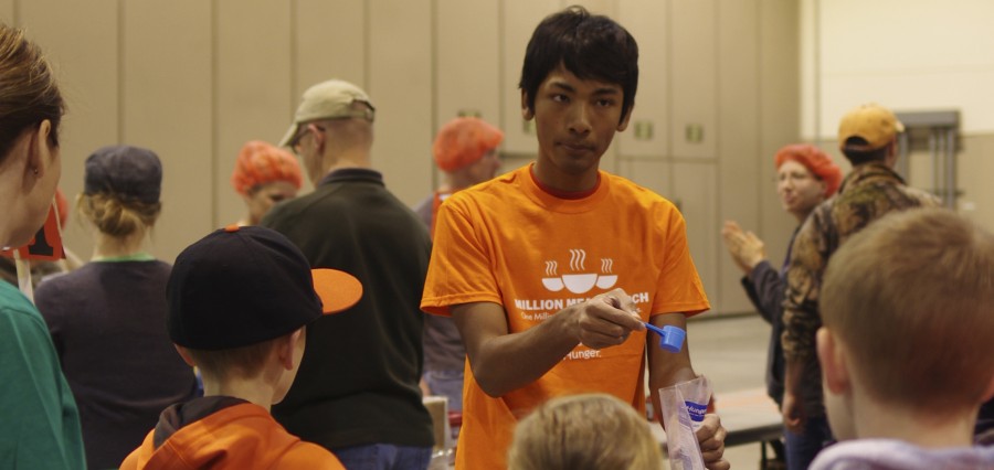 Senior Shaket Chaudhary packs meals at the Kids Against Hunger Million Meal March in April 2014. Chaudhary is doing one of the parts of the packing process assembly line. Photo courtesy of Max Slosburg