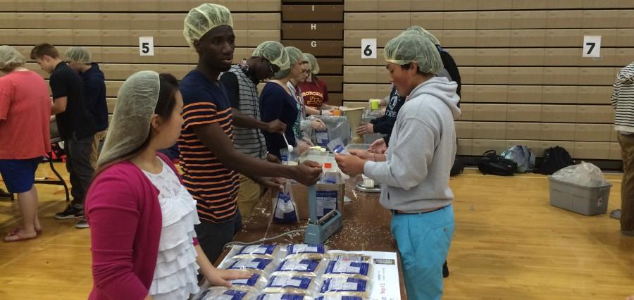 Seniors Njali Kowa and Jennifer Ahn, along with sophomore Zane Watanabe and a few other students, help pack meals during the Westside Kids Against Hunger 50,000 meal event Thursday, April 9. 150 students and staff showed up to pack meals. Photo by Aren Rendell
