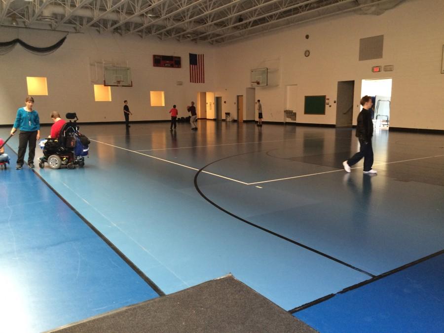Students play basketball in the blue gym for their physical activity. 