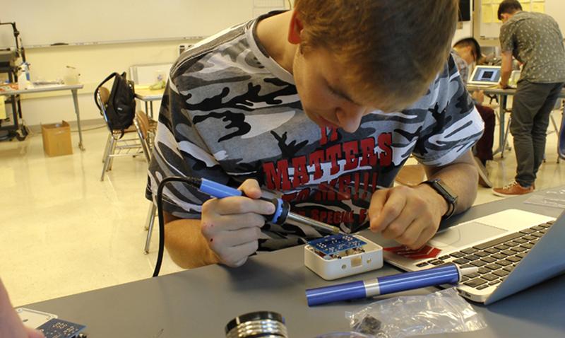Senior Jake Fauglid working on parts for the robot to make them operate.