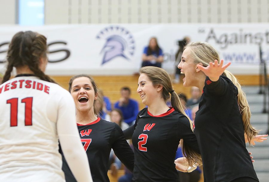 Seniors Jess Paprocki and Brooke Radica and junior Makenna Freeman celebrate after Freeman served an ace. The team fell to the Kearney bearcats in the first round of districts.