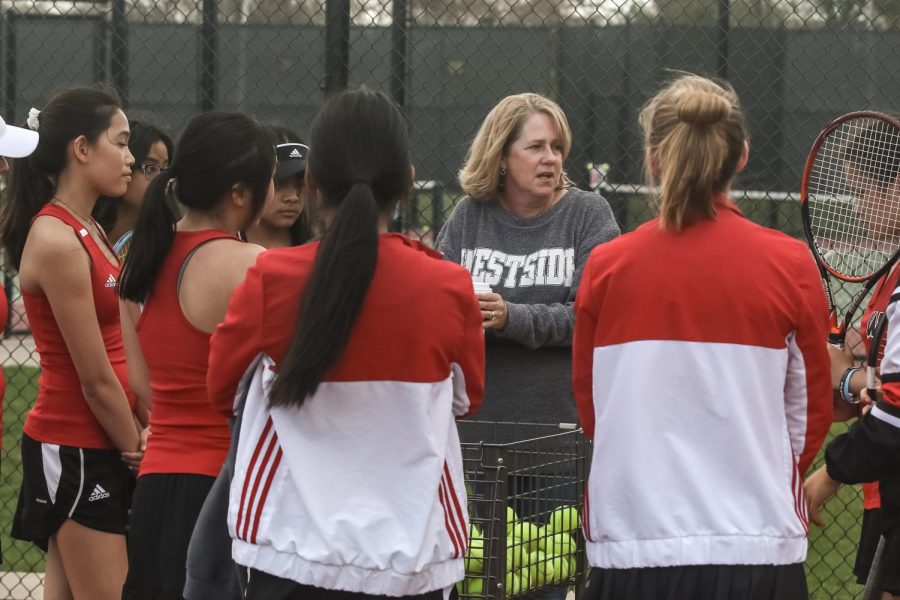 Head coach Jordane Warkentin speaks with her tennis players. 