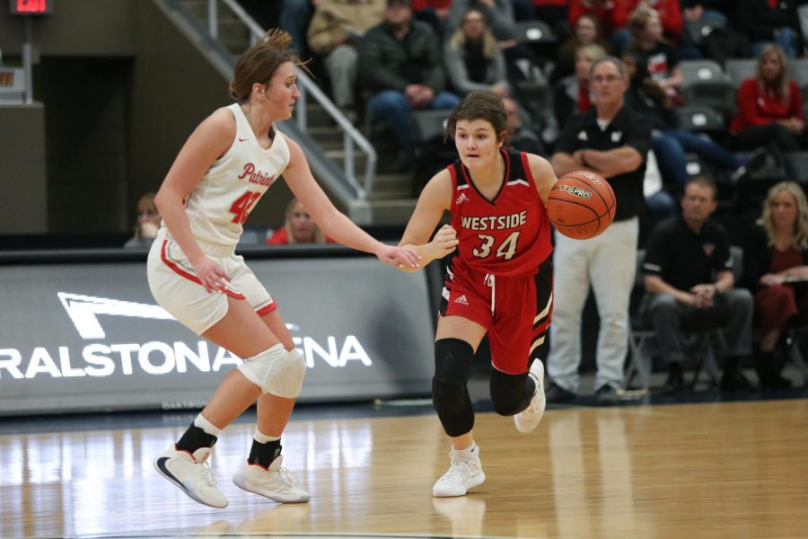 Westside senior Abby Hellman drives against Millard Souths Maddie Krull in the Metro Holiday Tournament championship game.