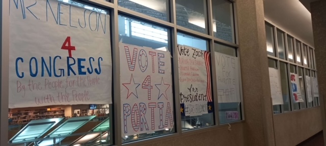 AP Government candidates hang posters in the hallway to promote their campaign.
