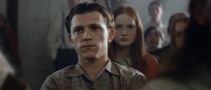 “The Devil All The Time” is directed by Antonio Campos and stars Tom Holland, Bill Skarsgård, Robert Pattinson, Riley Keough, Jason Clarke, and Sebastian Stan. The film is set in Knockemstiff, Ohio and revolves around sinister characters converging upon Arvin Russell (Holland) as he rids the evil forces that are threatening him and his family.