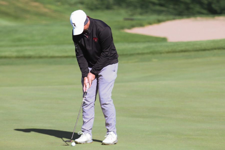 Jacob Hellman looks to putt in at the Lincoln Southwest. Hellman would later win the invite with a 70 and help the team win with a combined 304. Photo by Mary Nilius