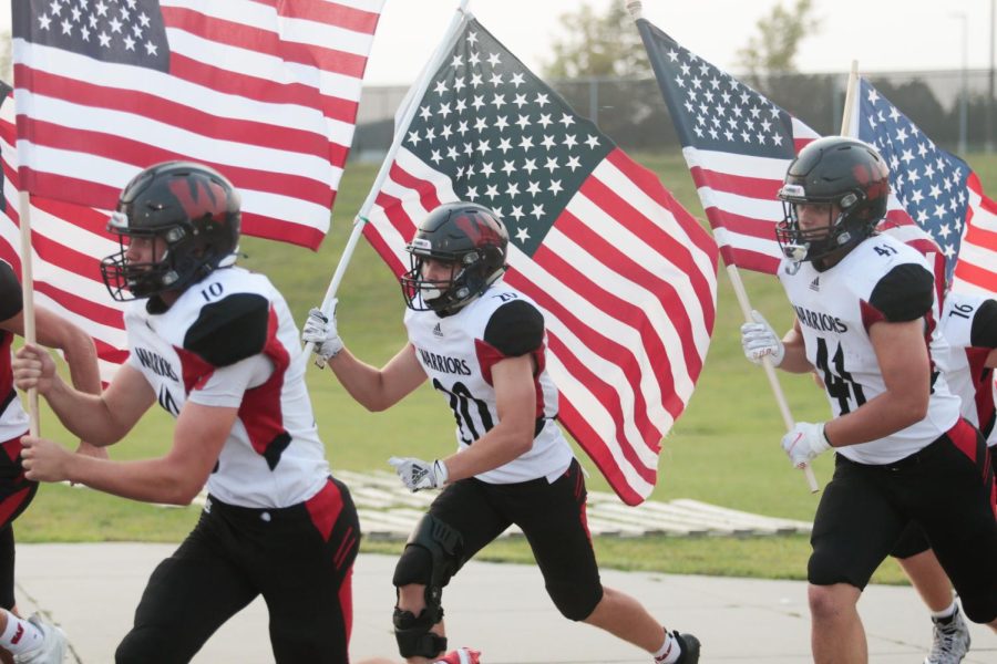 Kyle Vincentini brings out an American flag in their game up against Papillion-La Vista - Photo by Mary Nilius