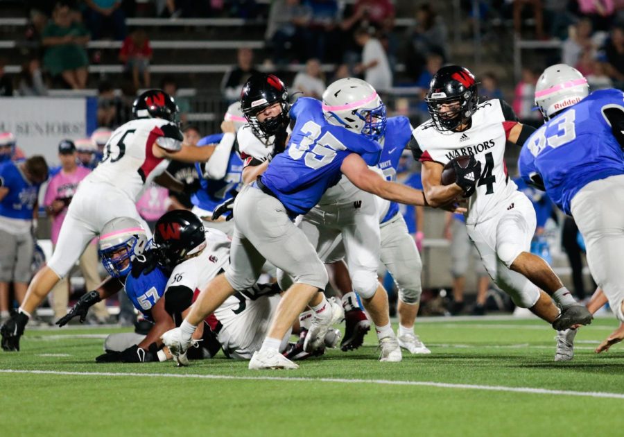 Westside running-back Curt Cubrich rushes at Westside’s game against Millard North. The Warriors have shown their depth in their running-game between Cubrich, Rezac and now Ross - Photo by Zoe Gillespie