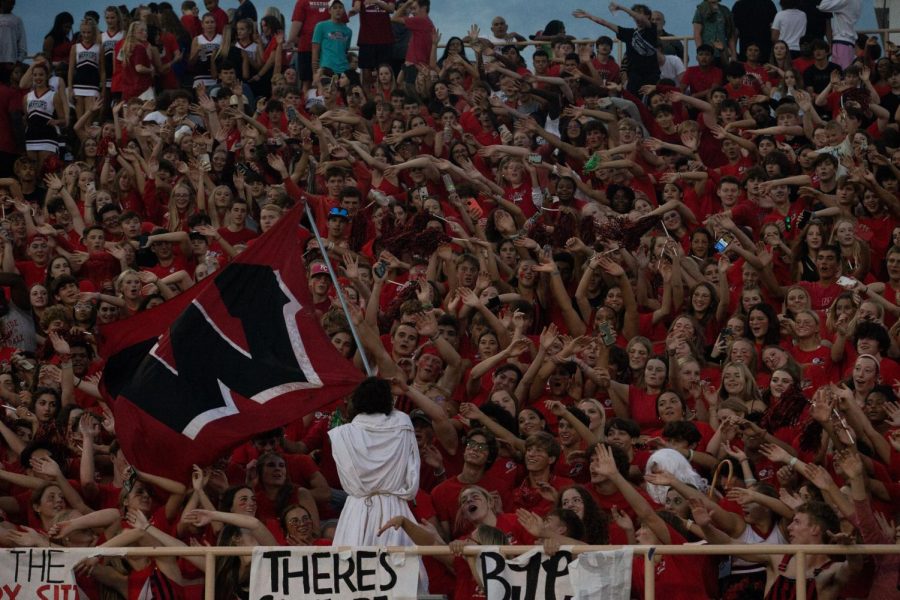 Red Shield leader Luke David waves a flag over the student section.