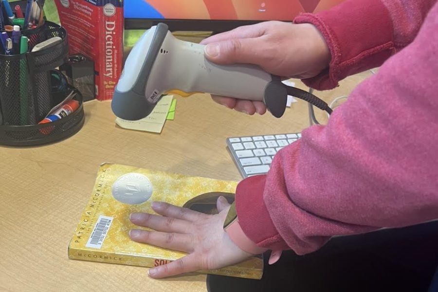 A newly barcoded book is scanned in the English/Foreign Language IMC. 