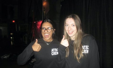 Seniors Amisha Subedi and Makayla Jones pose in their crew shirts while backstage.