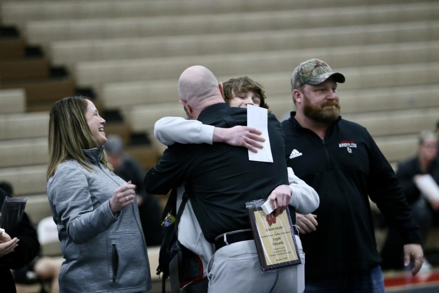Senior Logan Edwards hugs his coach on senior night.