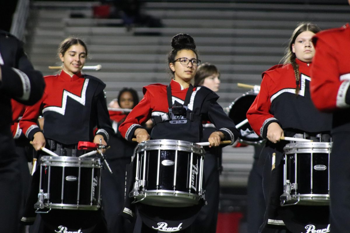Junior Bella Gerloff (center) enjoys being in drumline and hopes to continue challenging herself in piano and percussion.